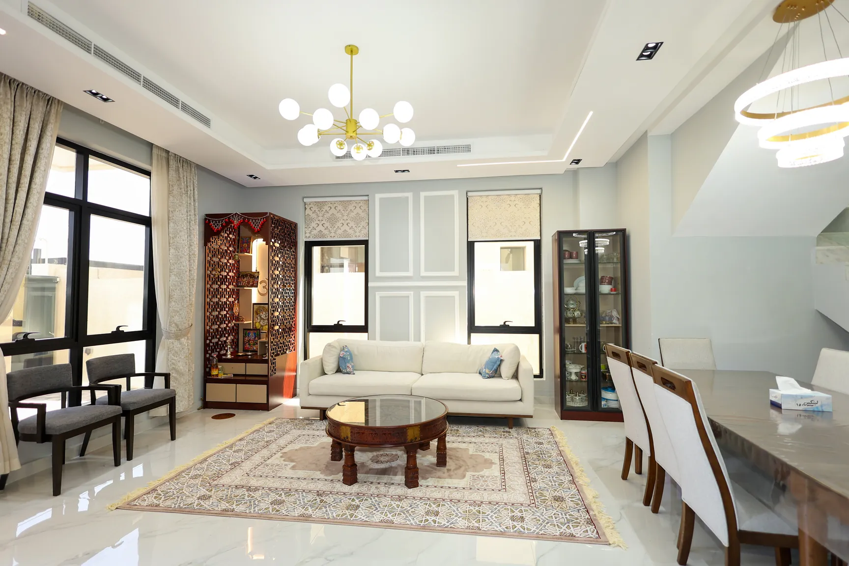 Ajman — Open living area with pale seating and decorative ceiling lighting