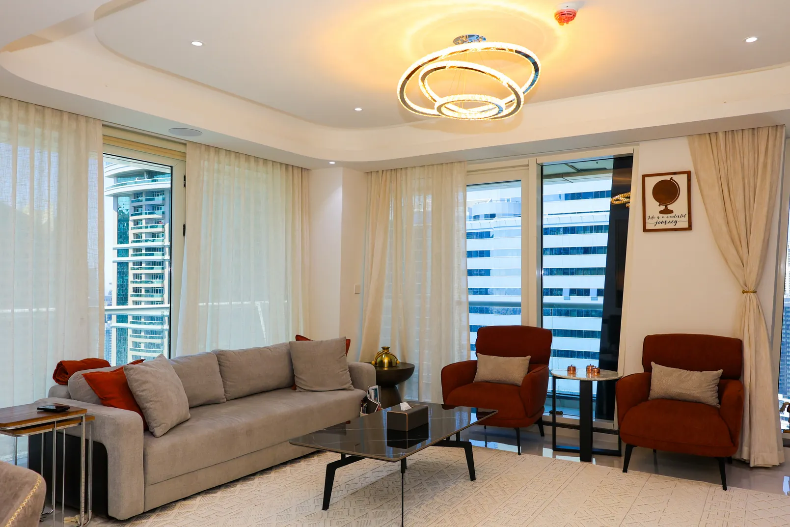 ARCTH Dubai — Living and dining area with pale seating and decorative ceiling lighting