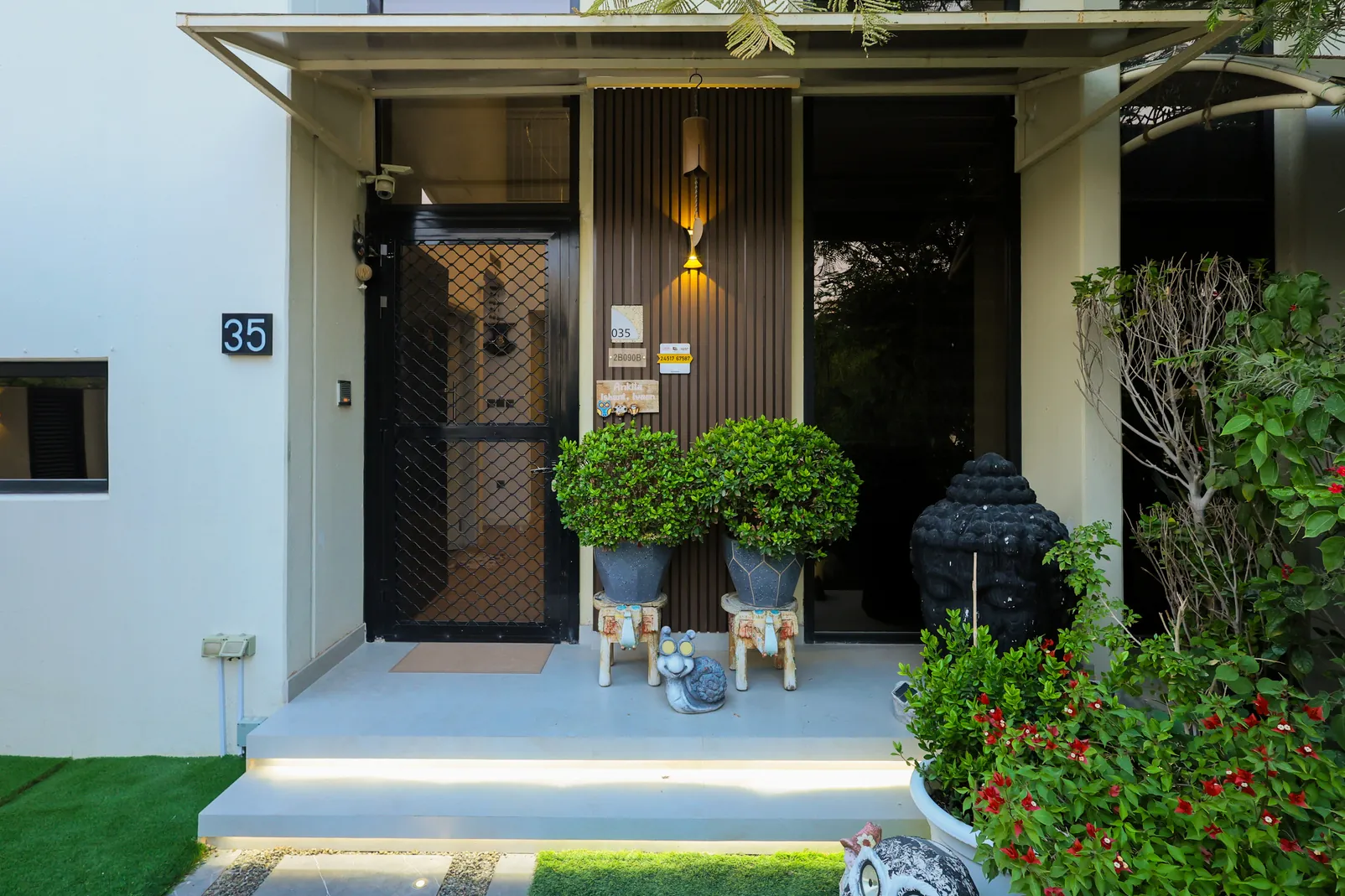 DAMAC Hills — Planted entrance with steps and a dark-framed doorway