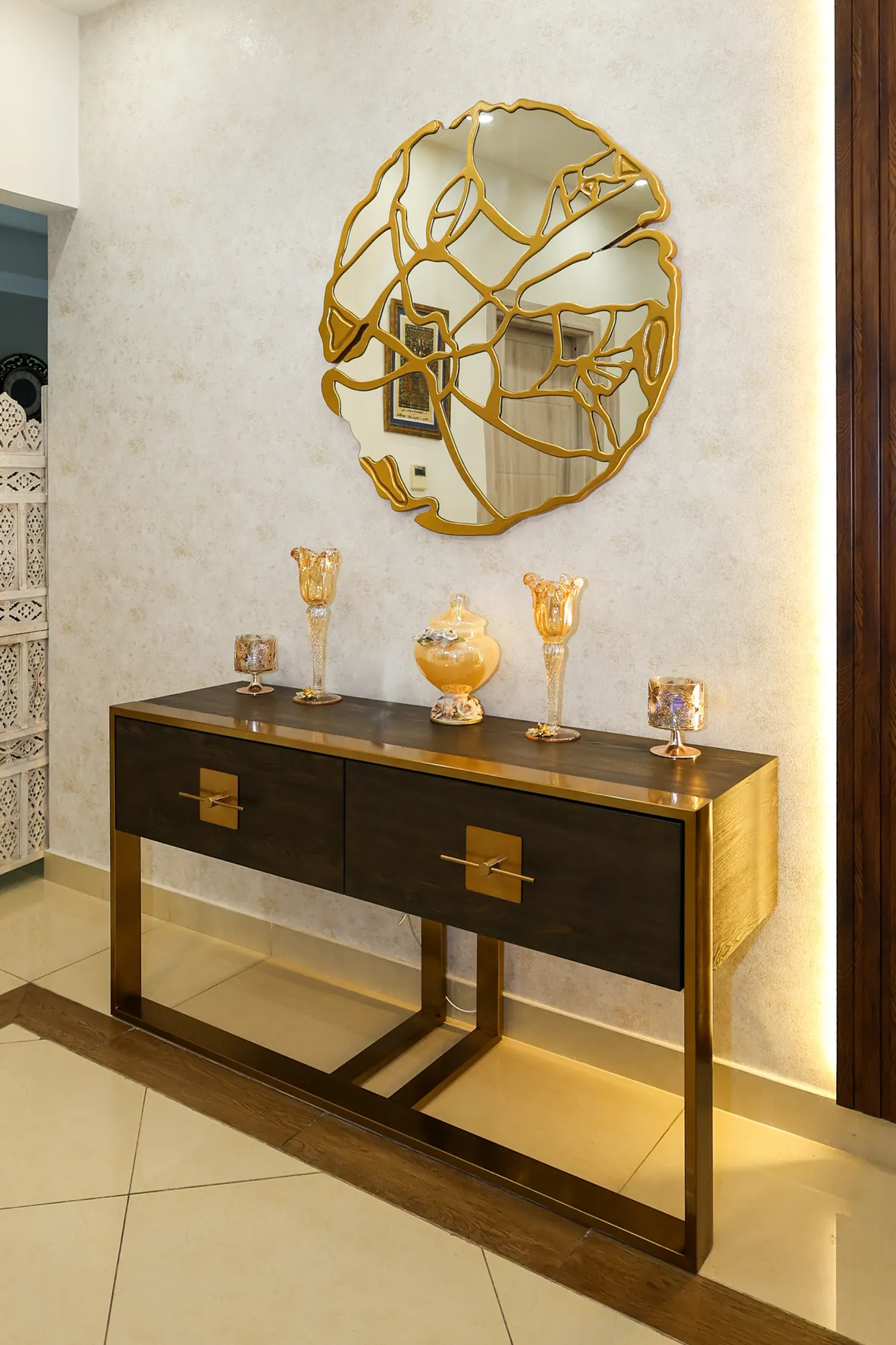 Mudon — Console table beneath wall art and accent lighting