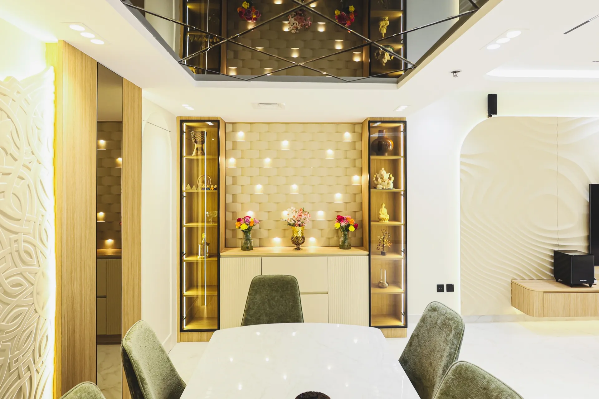 Dining area with illuminated display shelves, textured wall details and gold accents