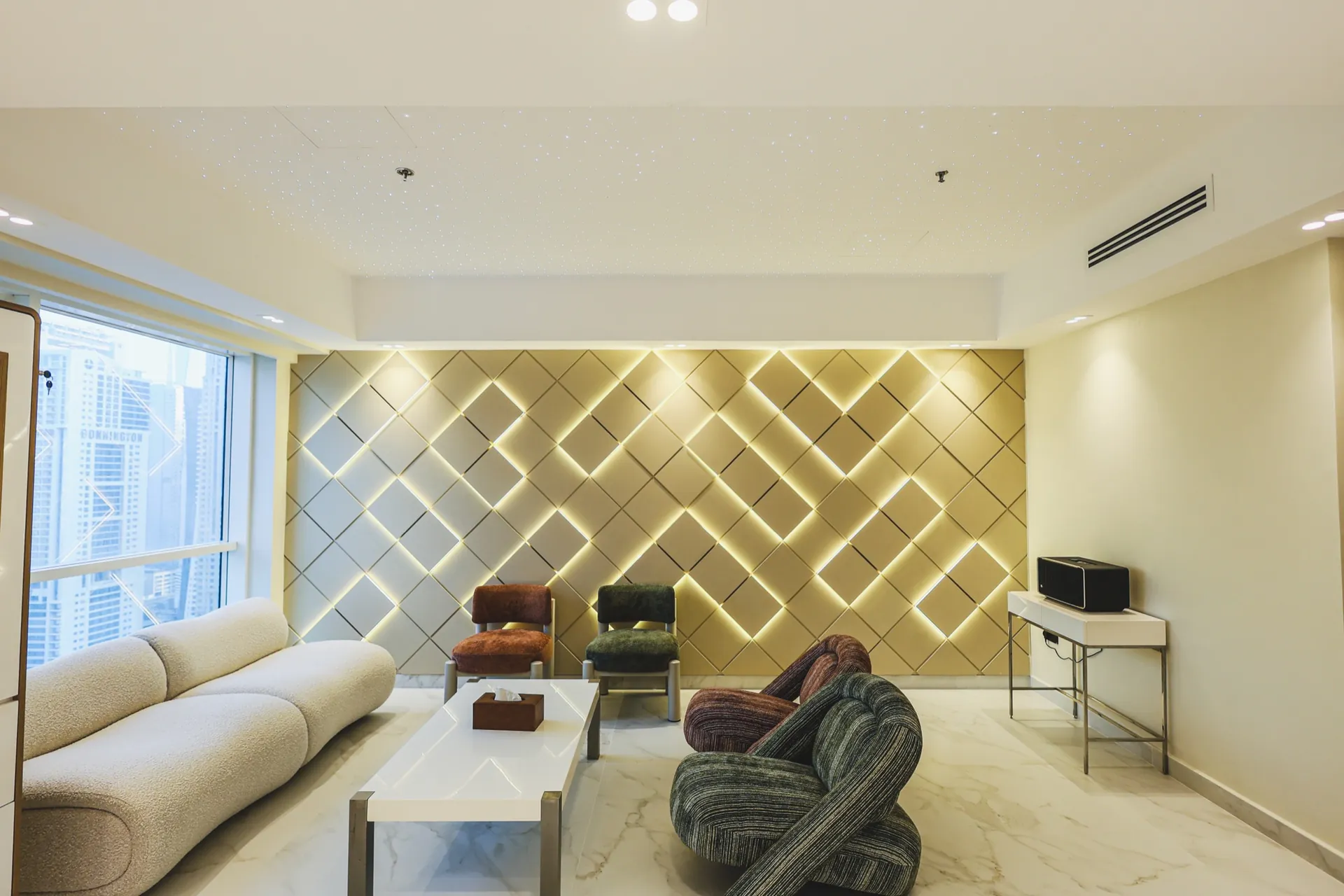 Lounge with sculptural seating and an illuminated geometric feature wall